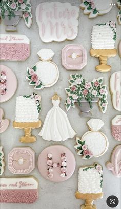 wedding cookies are arranged on a table with pink and white decorations, such as flowers