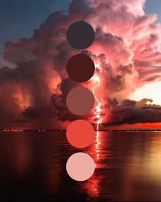 the sky is filled with clouds and colorful circles in front of water at sunset or sunrise