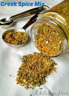 a jar filled with spices next to two spoons on top of a white cloth