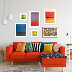 a living room with red couch and art on the wall