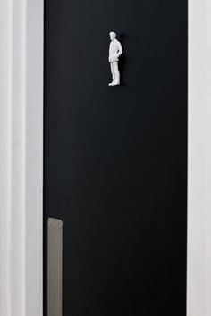 a black door with a white statue on it