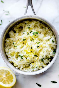 rice in a pot with lemon and parsley on the side, ready to be eaten