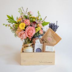 a wooden box filled with lots of different types of flowers and personal care products on top of a white surface