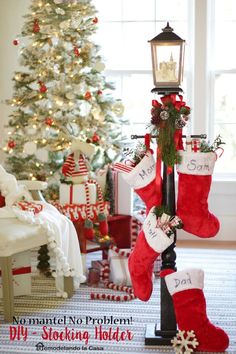 stockings hanging from a pole in front of a christmas tree