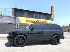 a black suv parked in front of a building