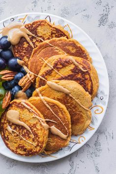 a plate with pancakes, grapes and pecans on it