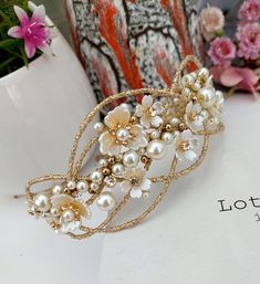 a close up of a tiara on a table with pink flowers in the background