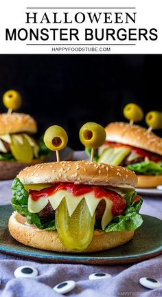 two hamburgers with pickles and cheese on them are sitting on a green plate