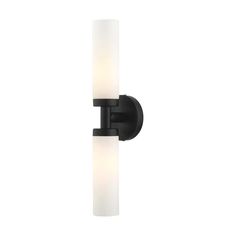 Livex Lighting is well known for quality, style and value. Add a dash of character and radiance to your home with this vanity sconce. This 2-light fixture from the Aero Collection features a black finish with 2 satin opal white glass cylinder shades on either side. The clean lines of the back plate complement the cylindrical glass shades creating a minimal, sleek, urban look that works well in most decors. This fixture adds upscale charm and contemporary aesthetics to your home. This well-rounde Ada Vanity, Bathroom Sconces Black, Hand Blown Glass Lighting, Blown Glass Lighting, Bathroom Sconces, Glass Cylinder, Livex Lighting, Bath Bar, Opal White