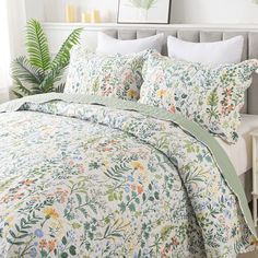 an image of a bedroom setting with flowers on the comforter and bed linens