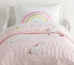 a pink bed with unicorns and stars on it