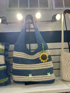 two crocheted bags sitting on top of a shelf