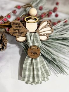 a wooden angel ornament with a cup of coffee on it's back