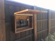 a wooden bird house built into the side of a fence