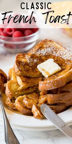 french toast with butter and syrup on a white plate next to raspberries in a glass bowl