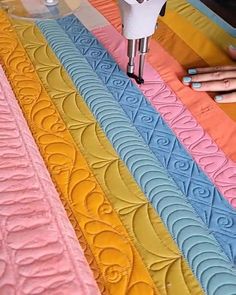 there are many different colored quilts on the table with crochet stitching