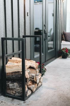 a stack of firewood sitting in front of a building