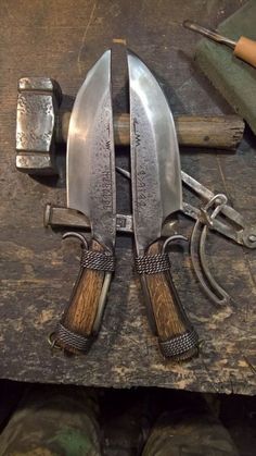 two knives and some other tools on a table