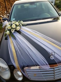 a wedding car decorated with flowers and ribbons