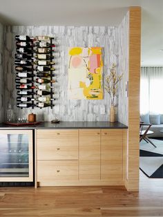 a wine rack in the corner of a room with bottles on it and a painting hanging above