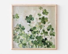 a painting with green leaves hanging on the wall