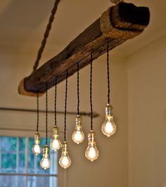 some light bulbs hanging from a wooden beam