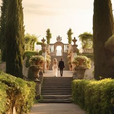 the bride and groom are walking down the stairs to their wedding ceremony in an italian garden