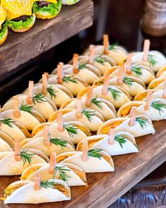 many small sandwiches are lined up on a table