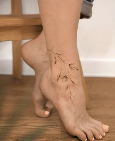 a woman's bare foot with a tattoo on her left leg and the bottom part of her legs