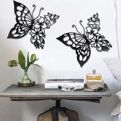 three metal butterflies on a wall above a table