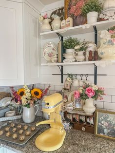 a yellow mixer sitting on top of a kitchen counter next to a cupcake tin