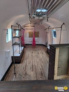 the inside of an airplane with wood flooring and metal racks on the ceiling,