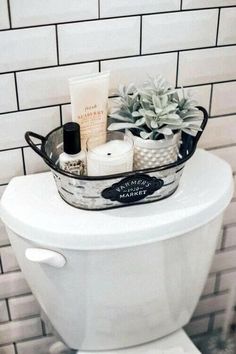 a white toilet with a metal basket filled with personal care items sitting on top of it