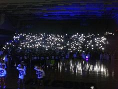 a group of people standing on top of a basketball court covered in white firework