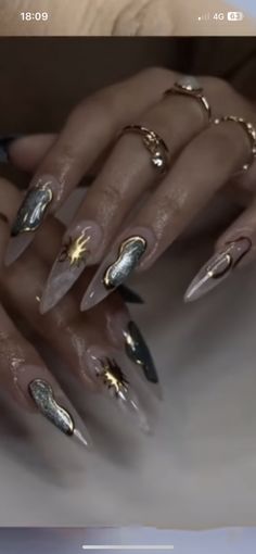 a woman's nails with gold and silver decorations