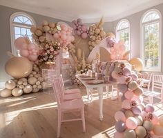 a room filled with lots of balloons and tables covered in pink, gold and white decorations