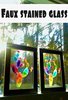 two stained glass windows sitting on top of a window sill with trees in the background