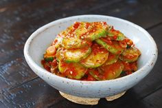 a white bowl filled with vegetables on top of a wooden table