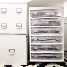 a white filing cabinet sitting next to a black and white checkered floor with drawers