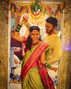 a man and woman dancing together in front of a mirror with garlands on it