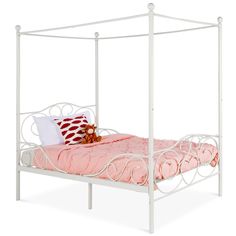 a white metal bed frame with pink bedspread and pillows on top of it