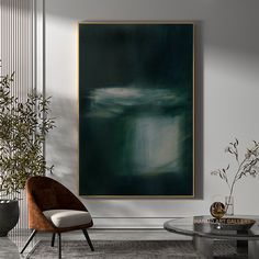 an abstract painting hangs on the wall next to a chair and coffee table in a modern living room