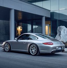 a silver sports car parked in front of a building