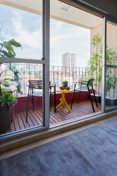 a balcony with chairs, table and potted plants