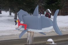 a shark mailbox sitting on the side of a road