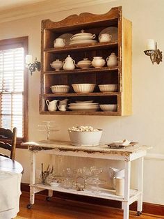 a dining room table with dishes on top of it and an old china cabinet in the corner