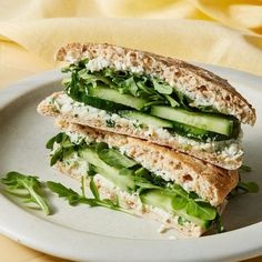 a sandwich with cucumber, cheese and lettuce is on a plate