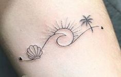 a woman's leg with a tattoo on it and palm trees in the background