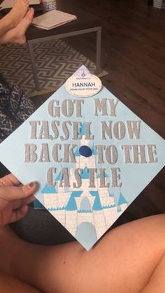 a person holding up a blue graduation cap with castle on it that says, got my tassel now back to the castle