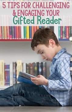 a young boy sitting on the floor reading a book in front of bookshelves